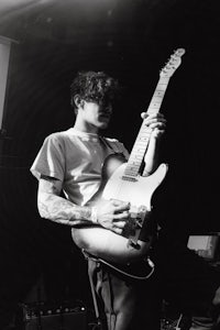 a black and white photo of a man playing an electric guitar