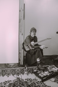 a man sitting in a room with a guitar